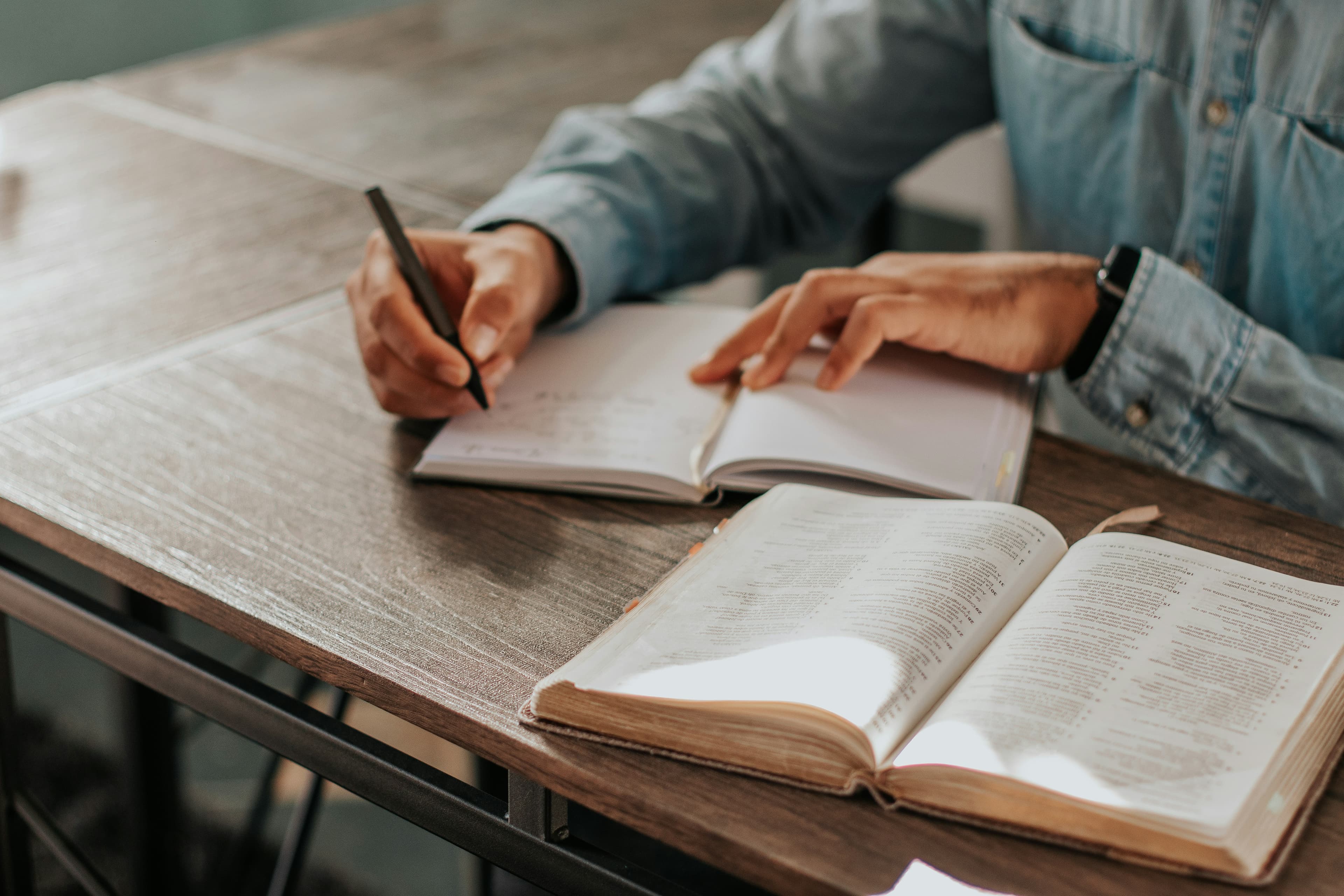 Persona estudiando la Biblia y tomando notas